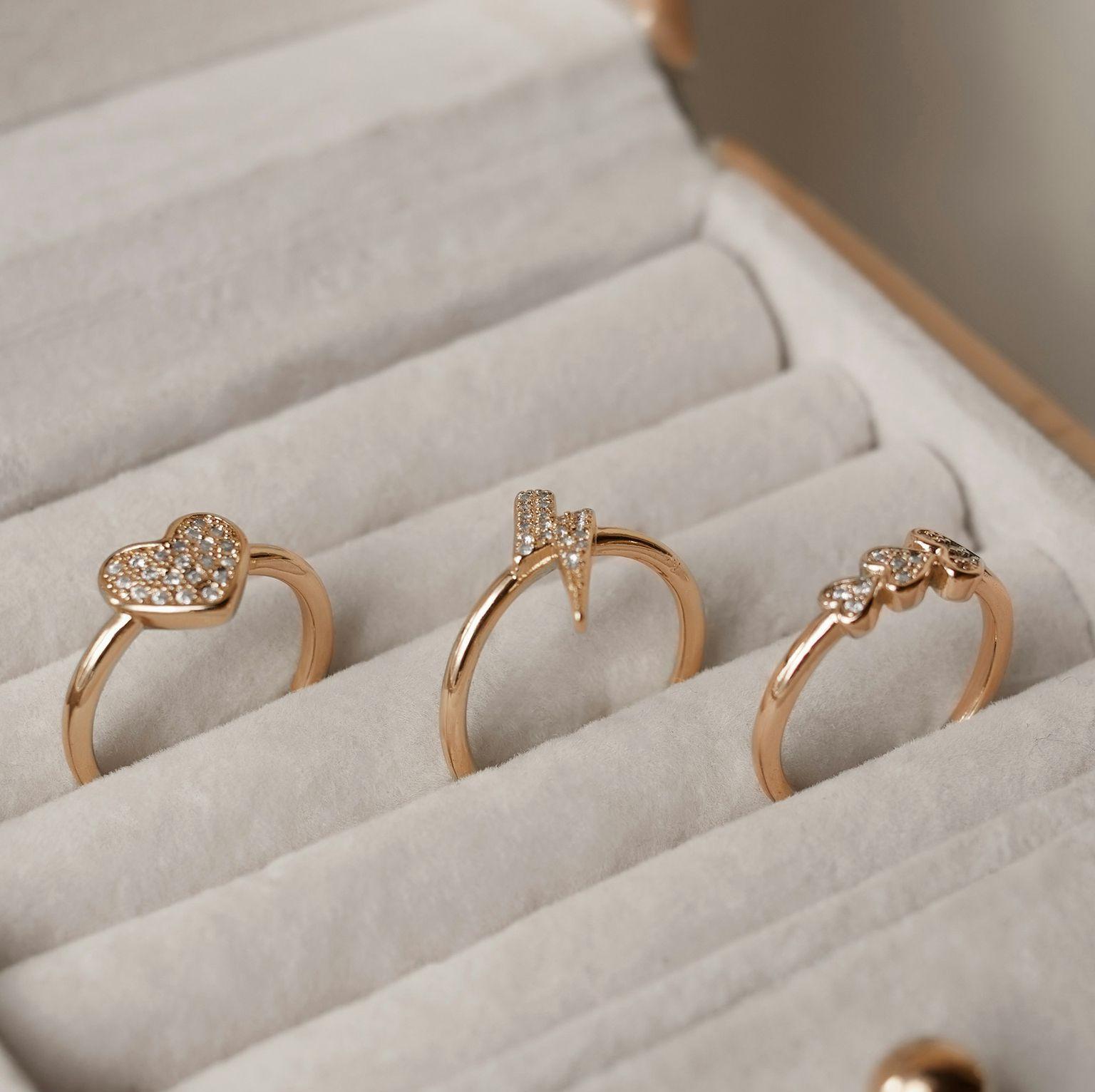 three gold rings in a white box